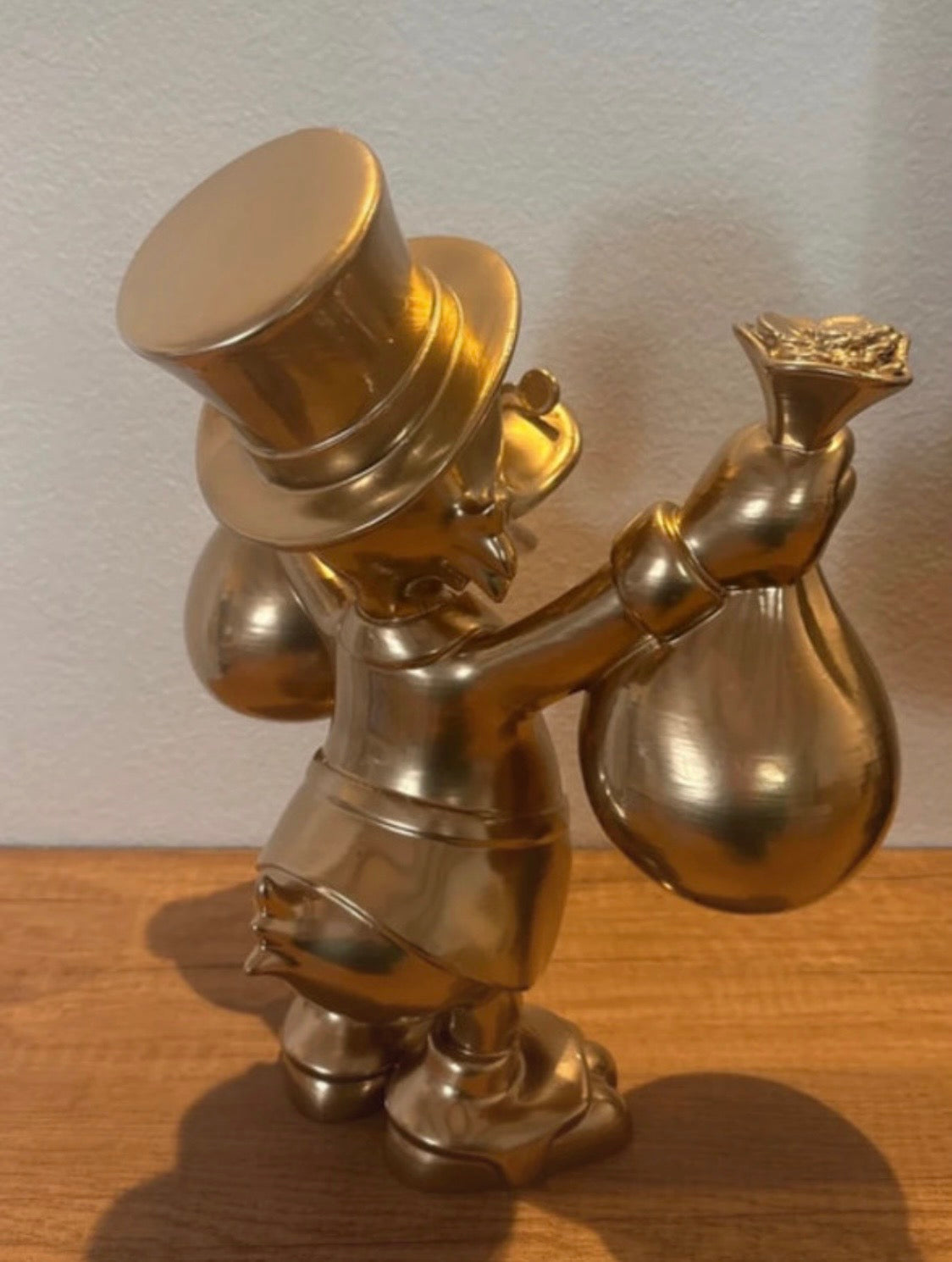 Dagobert Duck Goldstatue mit Geld und Beute