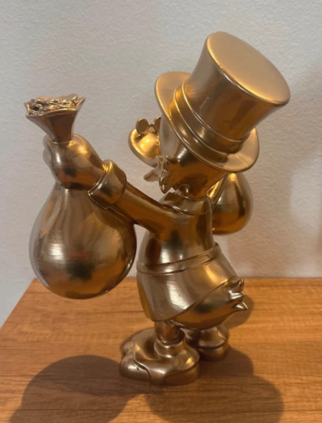 Dagobert Duck Goldstatue mit Geld und Beute