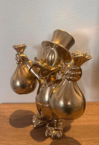Dagobert Duck Goldstatue mit Geld und Beute
