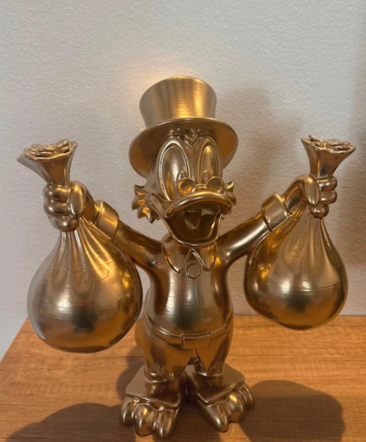 Dagobert Duck Goldstatue mit Geld und Beute